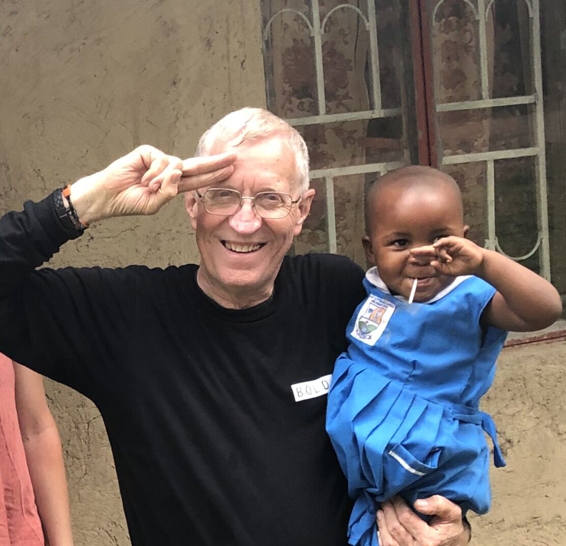 John Womack, founder of Greater Heights Missions, with a child in Uganda