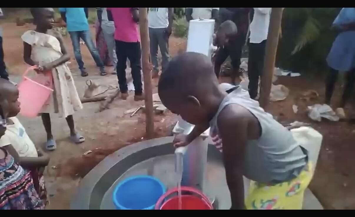 A child drinking clean water from a well